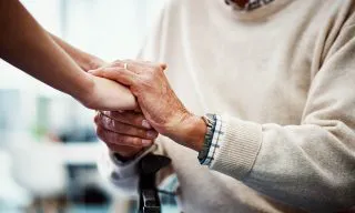 Cropped shot of an unrecognizable female nurse holding her senior patient's hand in comfort